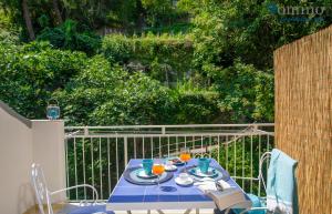 una mesa azul con platos y bebidas en el balcón en Casa Fornillo, en Positano