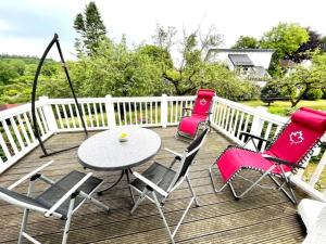 eine Terrasse mit 3 Stühlen und einem Tisch auf einer Terrasse in der Unterkunft romantische Ferienwohnung Sachsenhof 4 in Klingberg