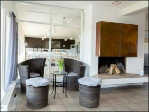 a restaurant with a fireplace and chairs and a table at Varbergs GK Östra Hotell in Grimeton