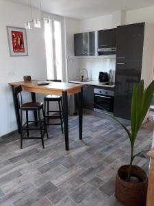 une cuisine avec une table et des chaises en bois ainsi qu'une plante dans l'établissement Appartement 35m2 au Mourillon, à 200m de la mer, à Toulon