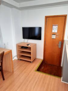 uma sala de estar com televisão e uma porta de madeira em Cobertura no melhor lugar de Ipanema (03) no Rio de Janeiro