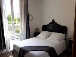 a bedroom with a bed with a black headboard and a window at Appartement 35m2 au Mourillon, à 200m de la mer in Toulon