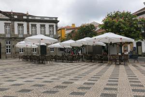 a group of tables and chairs with umbrellas at Aliança café & hostel in Angra do Heroísmo