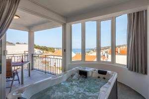 a jacuzzi tub in a room with a balcony at HOT TUB Sea View SPA in Hvar