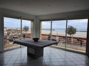 a table in a room with a view of the beach at T4 Front de mer Valras Plage in Valras-Plage
