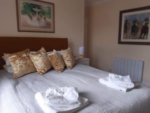 a bed with two towels sitting on top of it at Pulteney Road Apartment in Bath