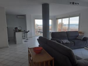 a living room with a couch and a table at T4 Front de mer Valras Plage in Valras-Plage