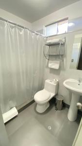 een badkamer met een wit toilet en een wastafel bij Hotel Casagrande in Arequipa