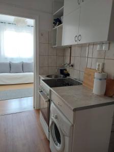 uma cozinha com máquina de lavar e secar roupa num quarto em B30 Apartman em Budapeste
