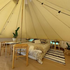 a bedroom with a bed in a tent at Jaagu metsatelk in Suuremõisa
