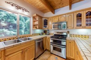 une cuisine avec des placards en bois et des appareils en acier inoxydable dans l'établissement Million Dollar Mountain View, à Crestline