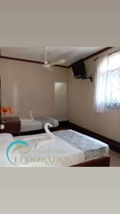 Hotel Familiar El Dorado في زيهواتانيجو: غرفة نوم بسريرين في غرفة