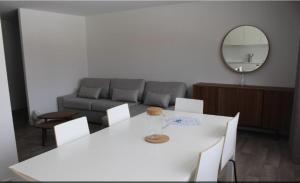 ein Wohnzimmer mit einem weißen Tisch und einem Sofa in der Unterkunft Lac et Montagne in Duingt