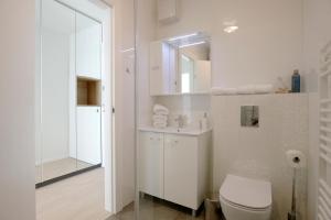 a white bathroom with a toilet and a mirror at Island View Luxury Apartments in Zadar