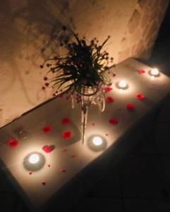 een vaas met bloemen en lichten op een tafel bij 26 Suite Home in Ostuni