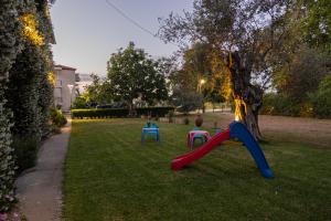 two children playing on a playground in a yard at Tsertos Apartments in Kamena Vourla