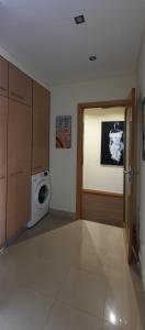 a laundry room with a washing machine and a door at Lendas de Portugal in Olhos de Água