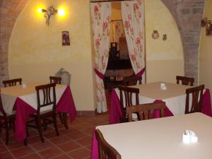 Country House Agriturismo Ciuccunit في Bucchianico: غرفة طعام مع طاولات وكراسي ومدفأة