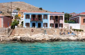 a house on the water next to a group of houses at Villa Leleka in Halki