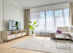 a living room with a couch and a tv at Kurkowa Apartments in Szczecin