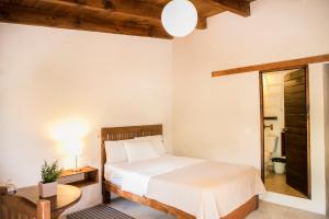 a bedroom with a bed and a table and a mirror at Meson de Valle Hotel in Valle de Bravo