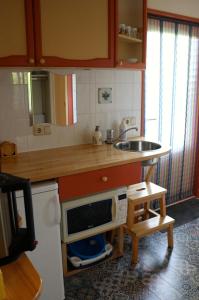 een kleine keuken met een wastafel en een magnetron bij perelaar in Langelille