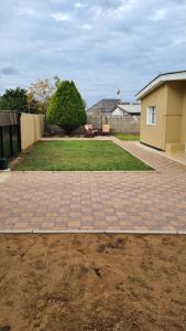 Una pasarela de ladrillo en un patio junto a una casa en Stone Villa, en Gaborone 2 fotos más