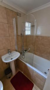 a bathroom with a sink and a tub and a toilet at Stone Villa in Gaborone
