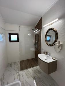 a white bathroom with a sink and a mirror at Pensiunea Izora in Crisan +26 photos