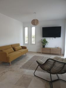 ein Wohnzimmer mit einem Sofa und einem Flachbild-TV in der Unterkunft Domaine U Filanciu - Maison Chiara avec piscine - Centre Corse in Moltifao