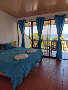 1 dormitorio con cama y vistas al océano en Hotel Cabinas Murillo, en Drake