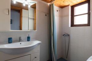 y baño con lavabo y ducha. en Villa Leleka en Halki