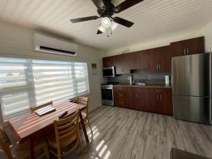 a kitchen with a table and a stainless steel refrigerator at PEI Cottage Rental in Borden-Carleton