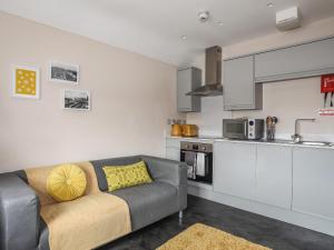 a living room with a couch and a kitchen at Cwm Gwyrfai in Caernarfon