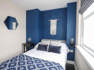 1 dormitorio azul con 1 cama con paredes azules en Cwm Gwyrfai, en Caernarfon