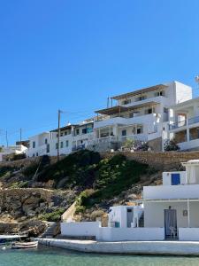 een groep witte huizen op een heuvel naast het water bij Droufakos’ home, Lux seafront apartment w. View in Sifnos