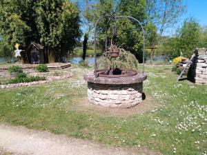 a stone fountain in the middle of a park at Au petit gravelot in Aulx-lès-Cromary +4 photos