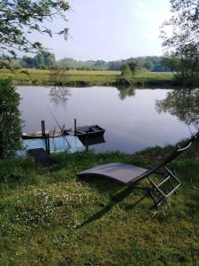 a boat sitting on the grass next to a lake at Au petit gravelot in Aulx-lès-Cromary