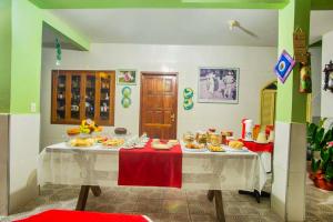 uma cozinha com uma mesa com pratos de comida em VOA Pousada Dos Jasmins em Serra