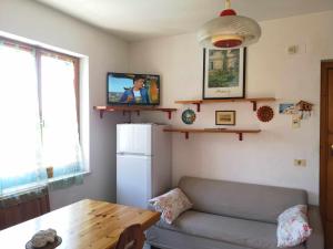 un soggiorno con divano, tavolo e TV di Costa Verde Casa Vacanze a Numana