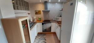 małą kuchnię z białymi szafkami i zlewem w obiekcie Appartement & Spa - Panoramic Olivars w mieście Pau