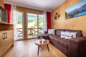 salon z kanapą i stołem w obiekcie Wellness- und Familienhotel Dachsteinresort w mieście Rußbach am Paß Gschütt