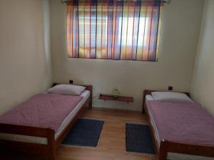 2 Betten in einem Zimmer mit Fenster in der Unterkunft Apartman Thea Gomirje in Gomirje