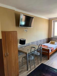 Cette chambre comprend une table, des chaises et un lit. dans l'établissement Hotelik Luna, à Jarosław