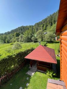 a building with a red roof on a field at Chata Zahura in Spišské Vlachy