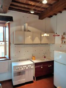 a kitchen with white cabinets and a stove top oven at vista sulla vallata in Pitigliano
