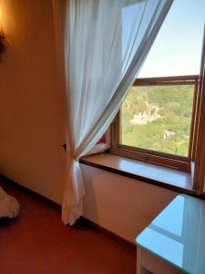 a window with a white curtain in a room at vista sulla vallata in Pitigliano