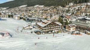 a group of people skiing down a snow covered slope at Hotel Hell in Ortisei