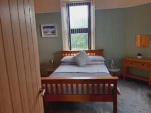 1 dormitorio con cama de madera y ventana en No.4 Bignold en Wick