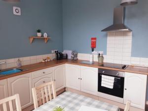 a kitchen with white cabinets and a stove top oven at No.4 Bignold in Wick